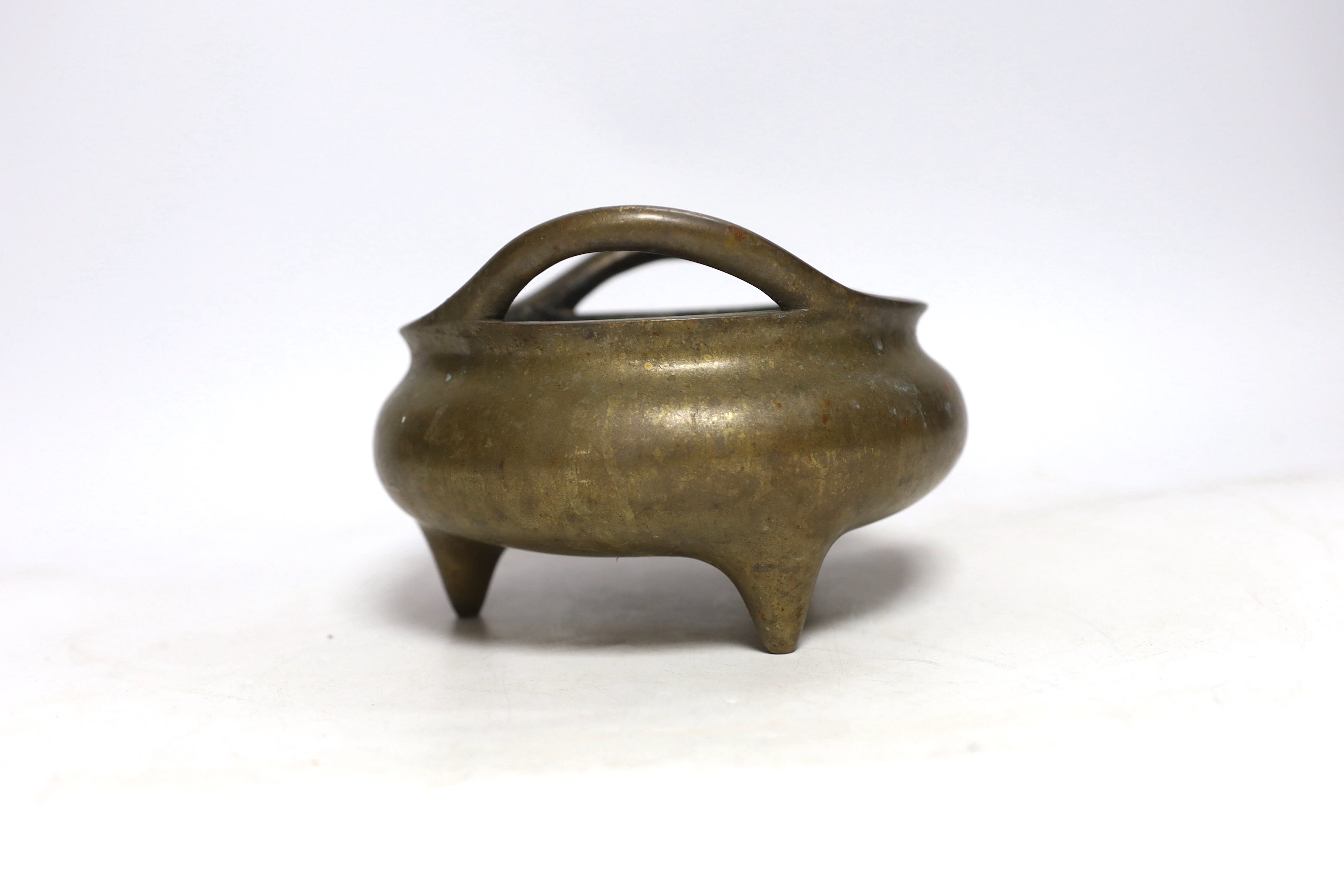 A Chinese bronze censer with twin handles and tripod feet, 18cm wide